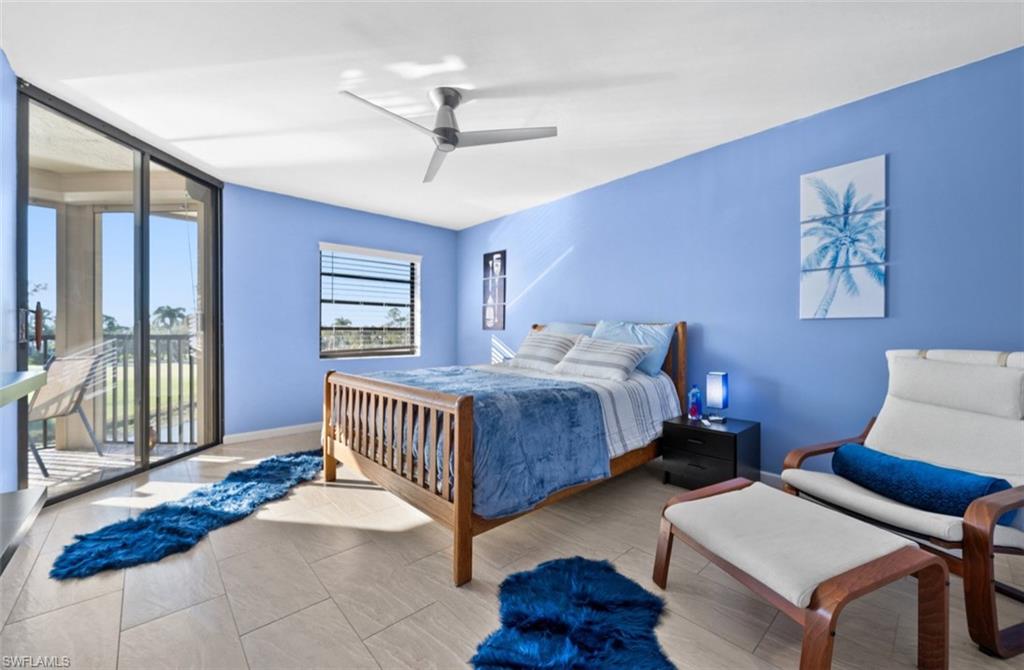 Spacious room with light-toned tile flooring, a large sliding glass door, and a single window with horizontal blinds