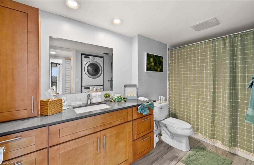 Wood-finish vanity with an integrated sink, polished chrome faucet, and gray countertop