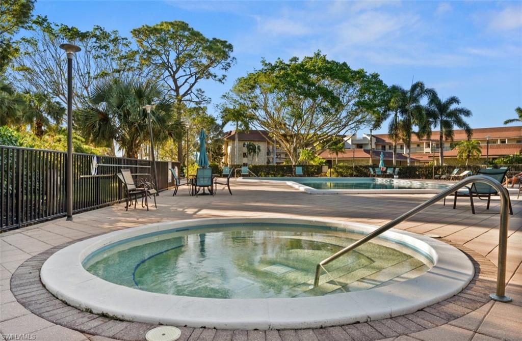 Circular spa with an integrated handrail, accompanied by an adjacent rectangular swimming pool