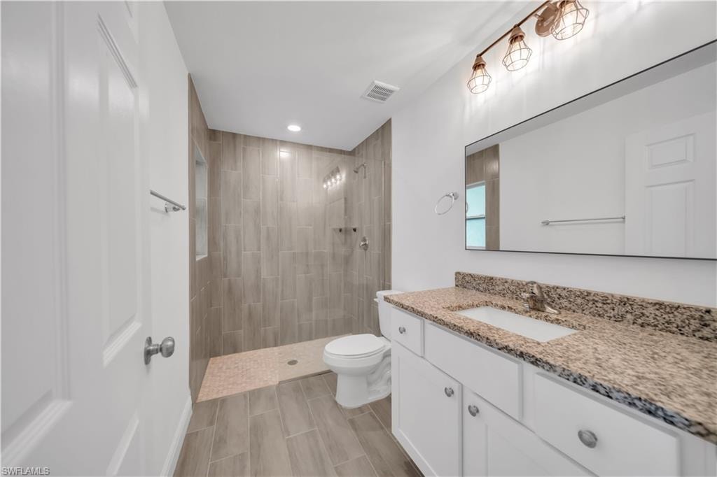 Walk-in shower with wood-look tile surround and mosaic tile floor