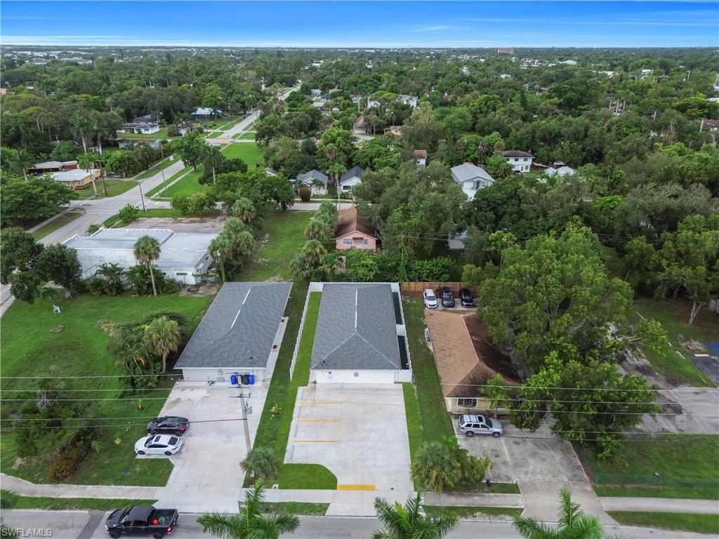 Two structures with gray shingle roofs and concrete driveways