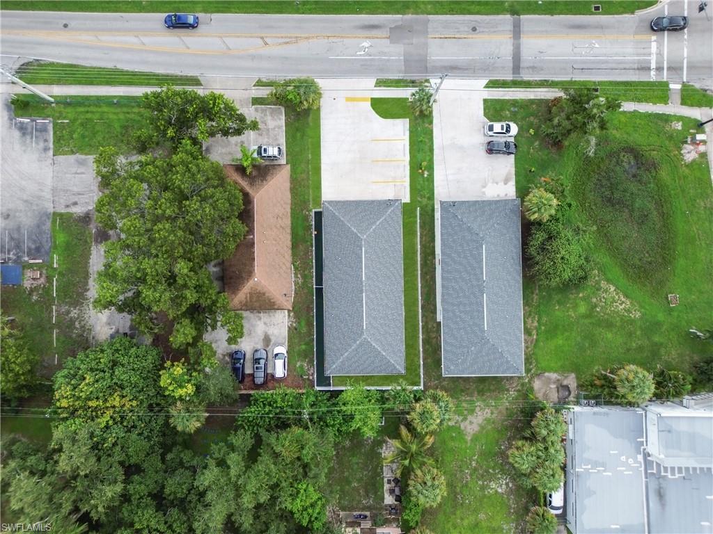 Three distinct structures with varied roofing, extensive surrounding greenery, and direct road access