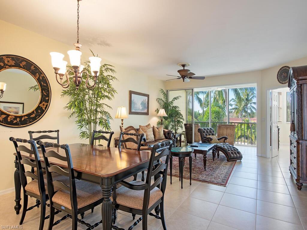 Tiled dining area with ceiling fan with notable chandelier