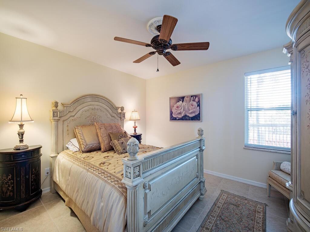 Tiled guest bedroom featuring ceiling fan