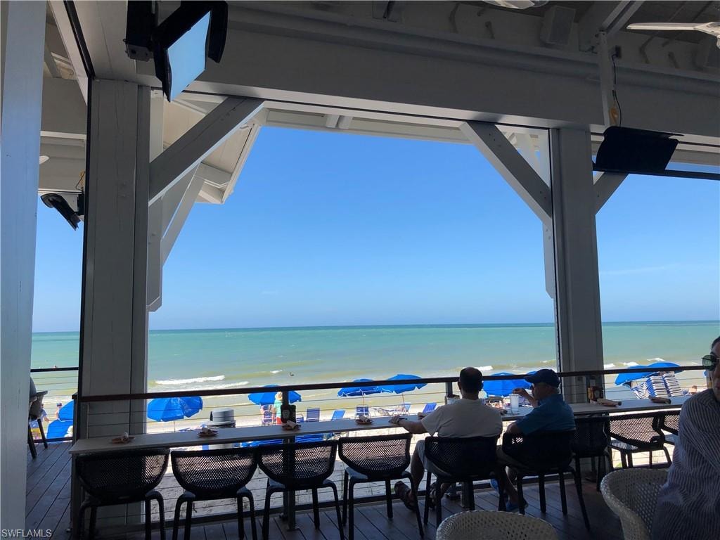 View of patio featuring a water view, a view of the beach, and a balcony