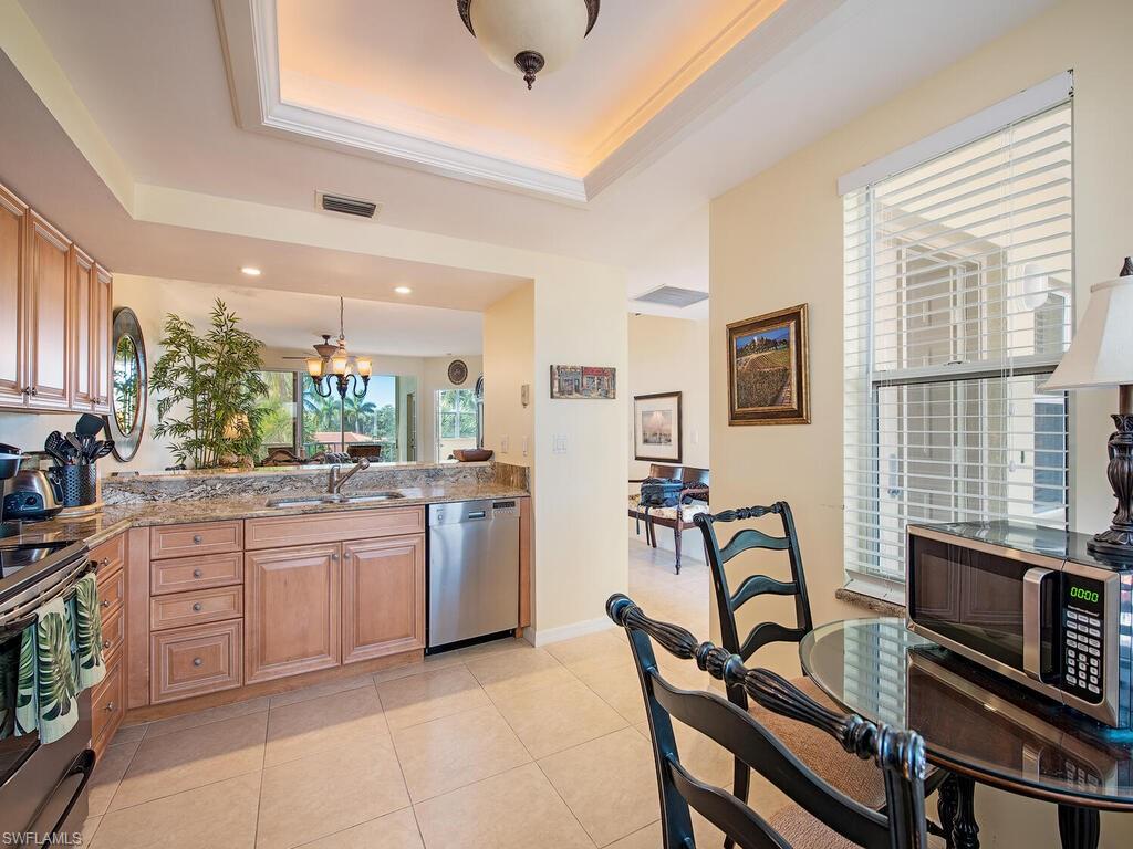 Kitchen with a chandelier, stainless steel appliances, sink, and a raised ceiling