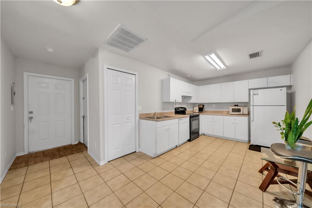 Kitchen featuring white cabinetry, light-toned countertops, and tile flooring