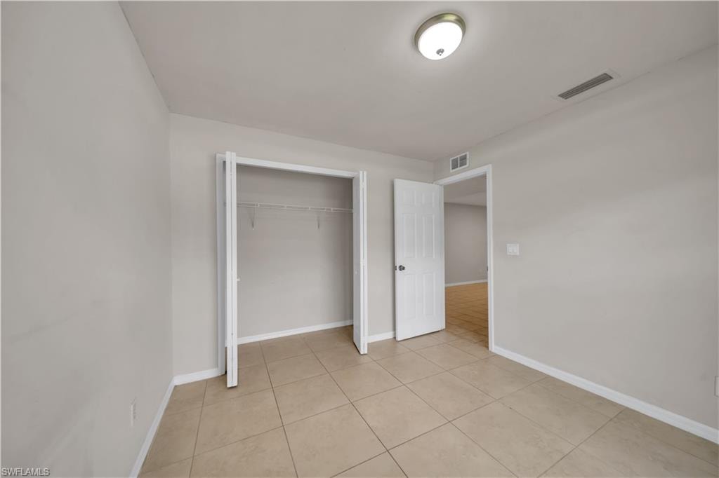 Neutral-toned tile flooring, light gray wall paint, and a ceiling-mounted light fixture