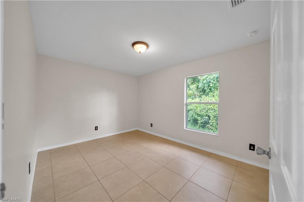 Neutral wall color, tiled flooring, single window, and a ceiling-mounted light fixture