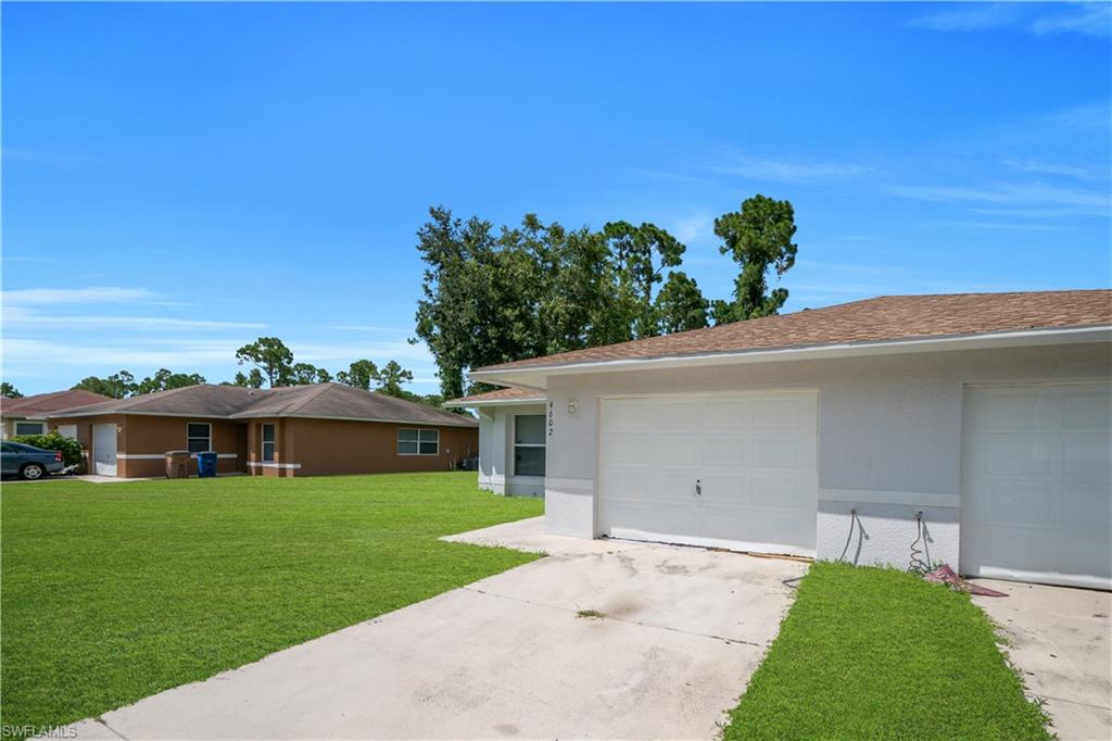 Two single-car garage doors, concrete driveway, and a shingle roof