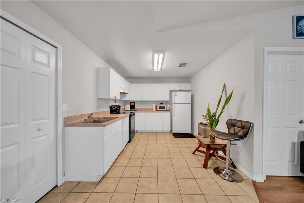 Kitchen with white cabinetry, light-toned countertops, and tile flooring