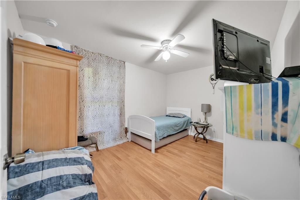 Wood-finish flooring with white walls and a ceiling fan