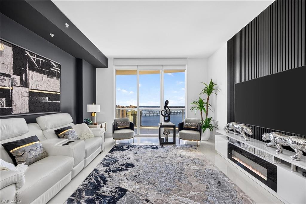 Bright living area featuring a large glass slider, sleek entertainment console with an integrated fireplace, and a striking black slatted accent wall