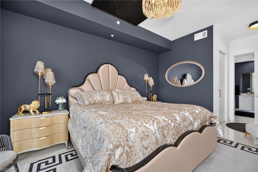 Recessed lighting, contemporary chandelier, ceiling trim detail, flat panel door, light-toned flooring