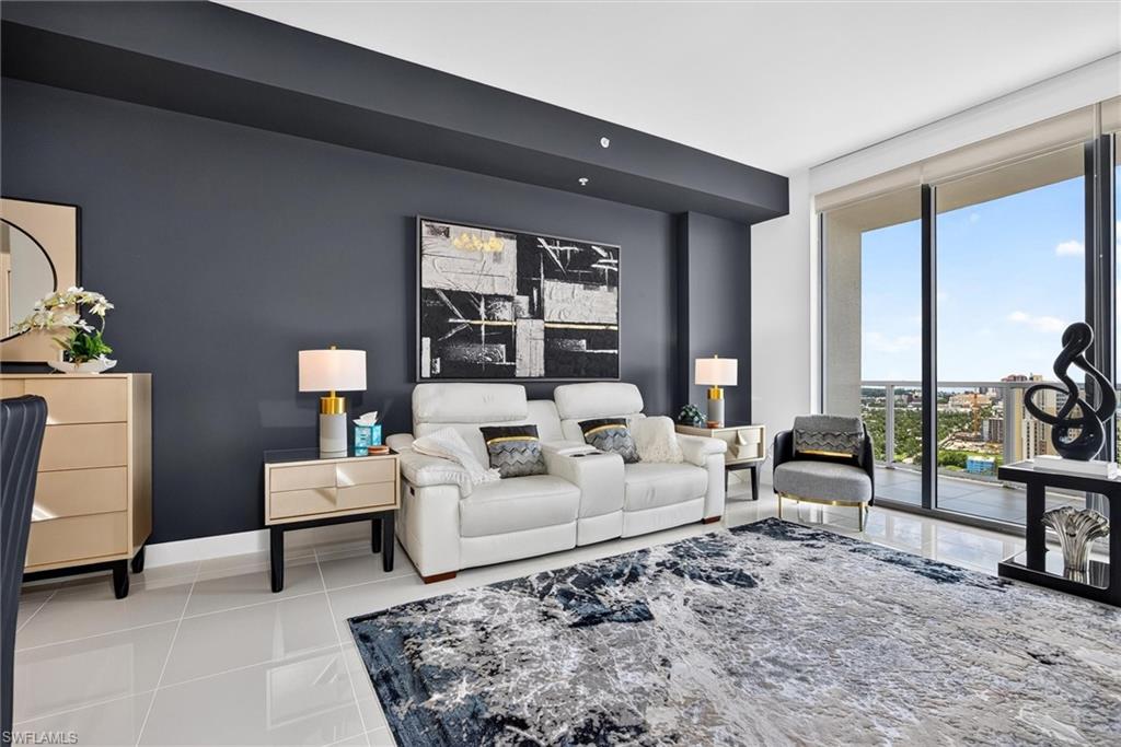 Expansive floor-to-ceiling glass doors, sleek tile flooring, dark accent wall, and recessed lighting