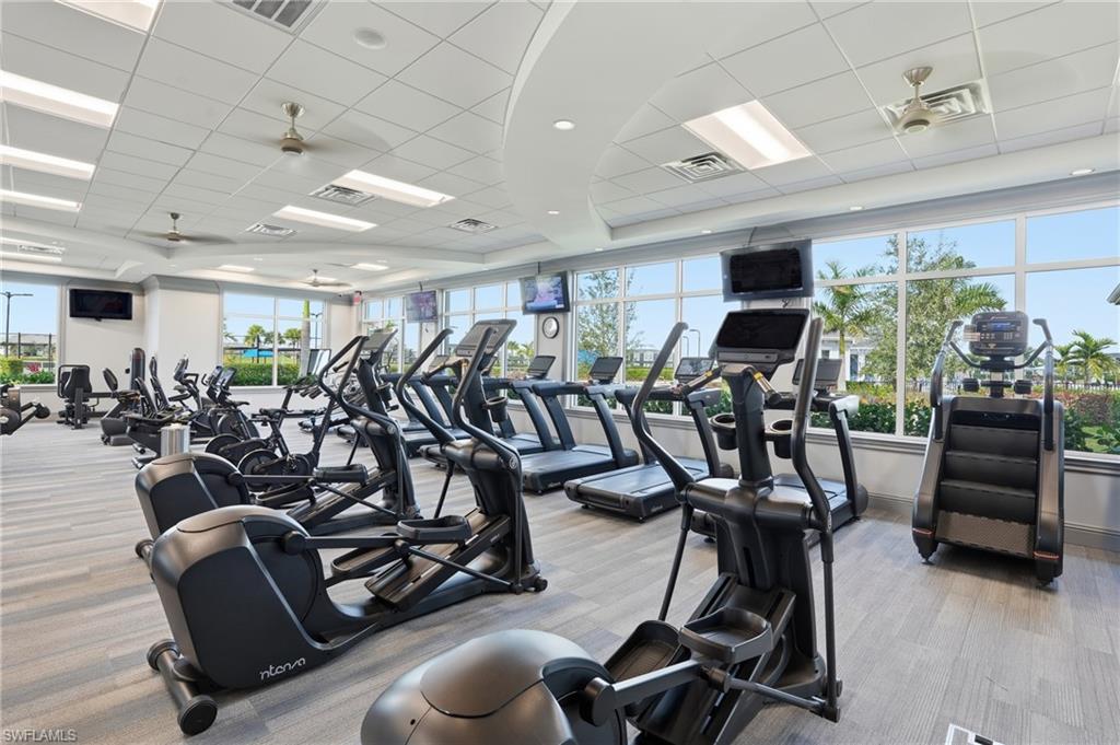 Fitness center featuring multiple exercise machines, large windows, ceiling fans, recessed lighting, and patterned carpet flooring
