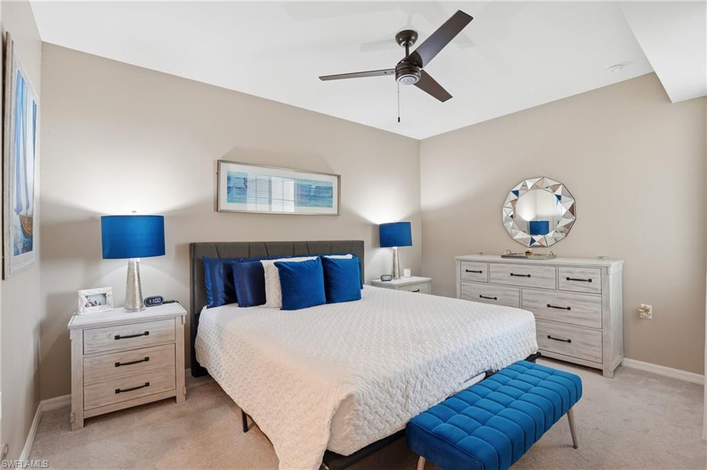 Neutral wall color, plush carpeting, ceiling fan with integrated lighting, built-in recessed lighting, and a paneled accent wall