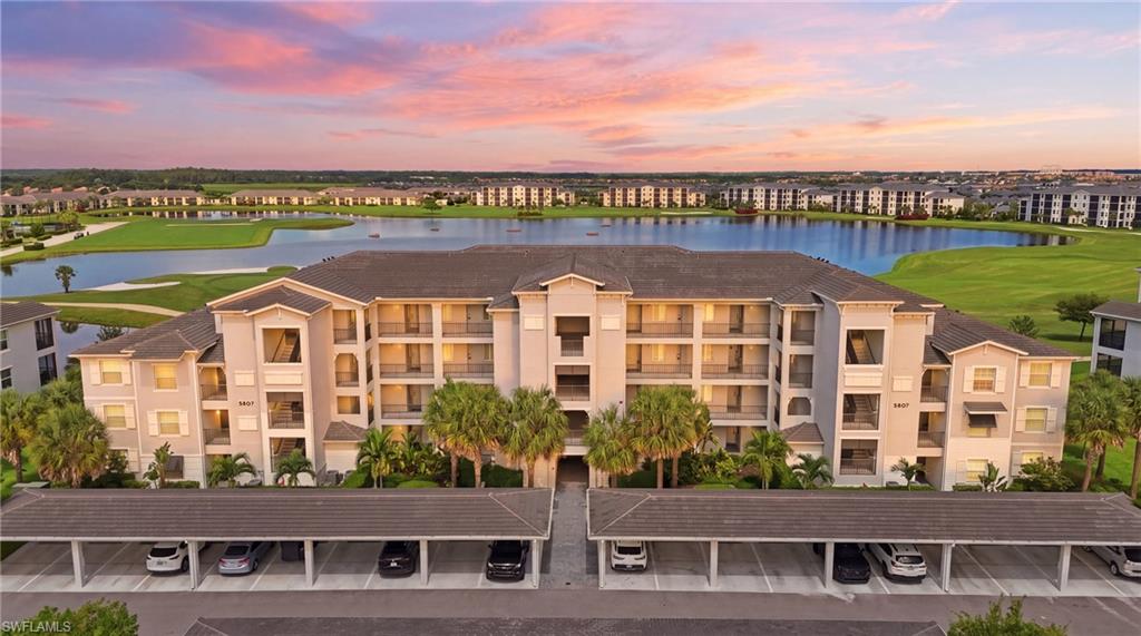 Building 46 Multi-story condominium building featuring multiple balconies, covered parking, and landscaping with palm trees