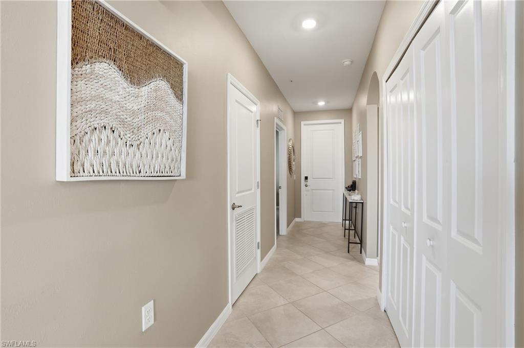 Hallway featuring light-toned walls, recessed lighting, and tile flooring