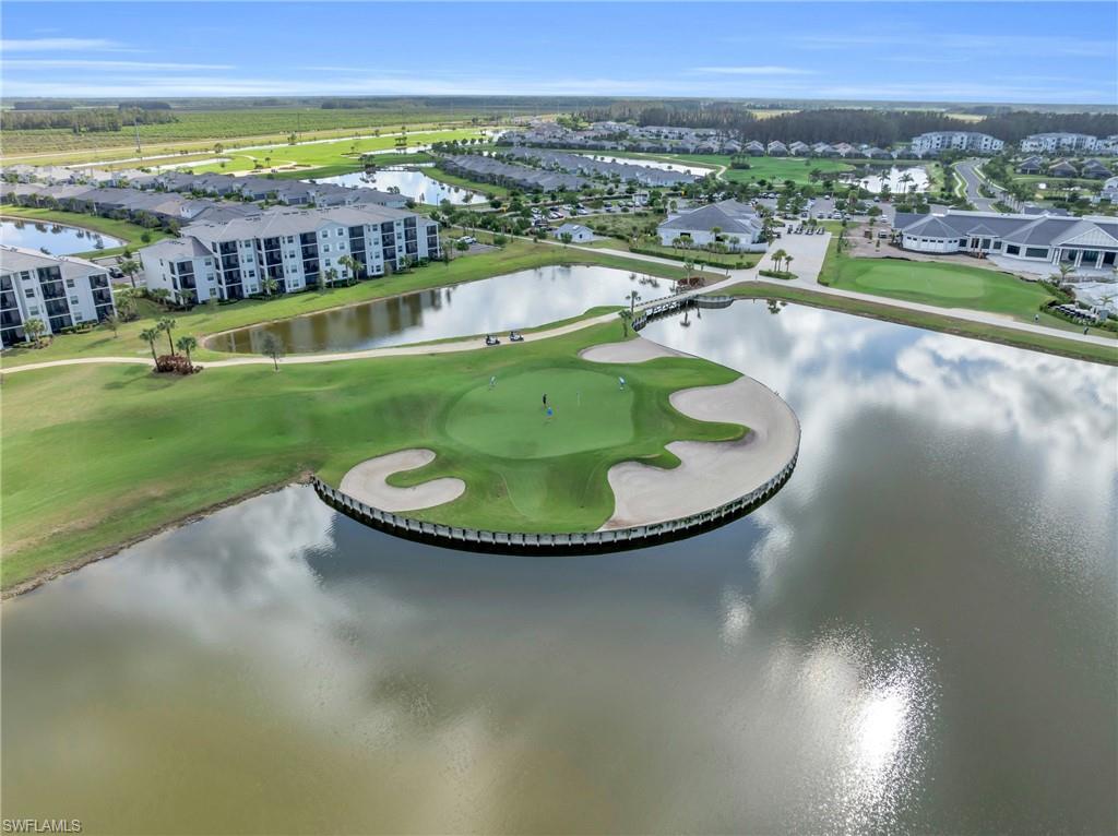Elevated golf course property featuring an island green, surrounding water features, and manicured landscaping