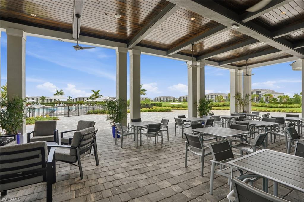 Covered outdoor patio with a wood-finish ceiling, exposed beams, and ceiling fans