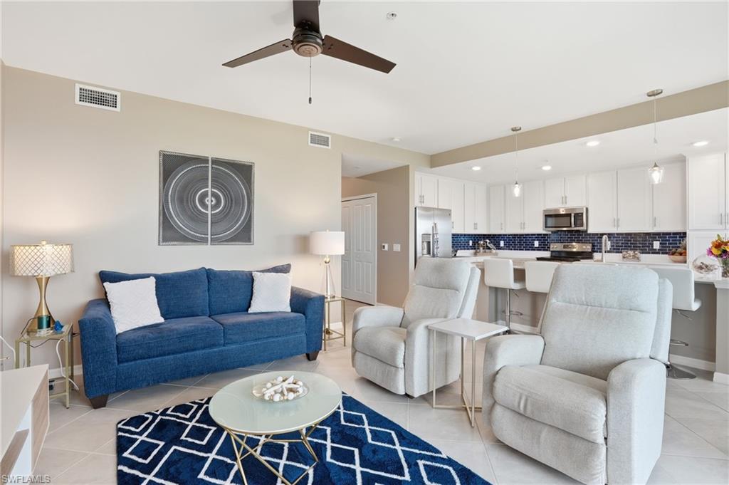Open-concept living space featuring a ceiling fan, light-toned wall paint, and tile flooring