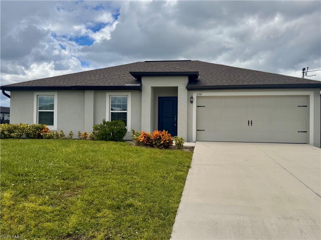 View of front of property featuring an attached garage, driveway, stucco siding, a front lawn, and roof with shingles