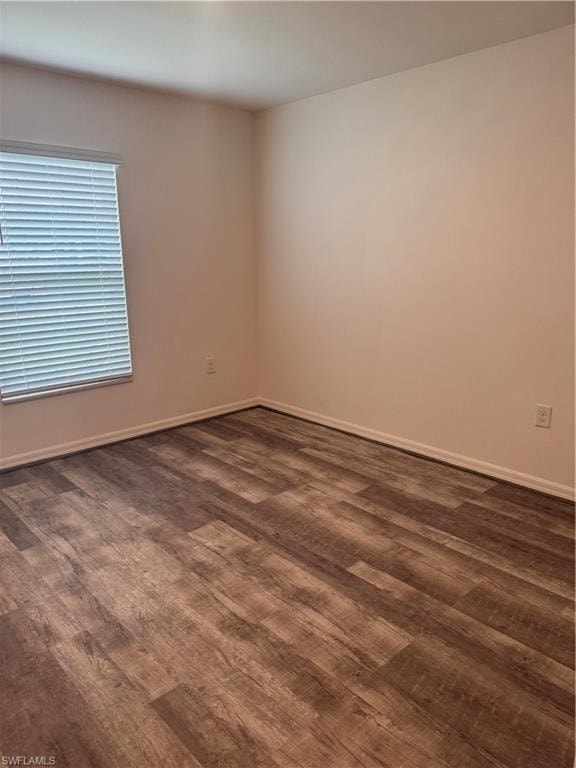 Empty room with dark wood-type flooring