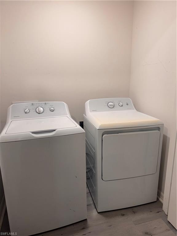 Laundry area with light wood-style flooring and washing machine and dryer