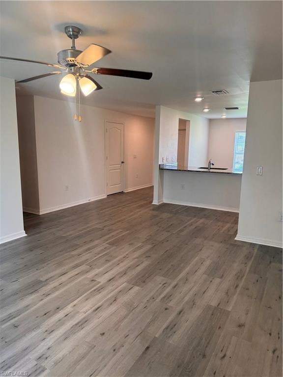 Unfurnished living room with dark wood-style flooring and ceiling fan