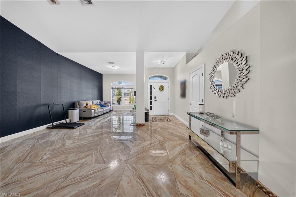 Polished tile flooring, recessed lighting, and a white paneled door