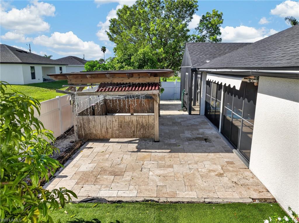 Expansive paver patio with a screened enclosure and a retractable awning