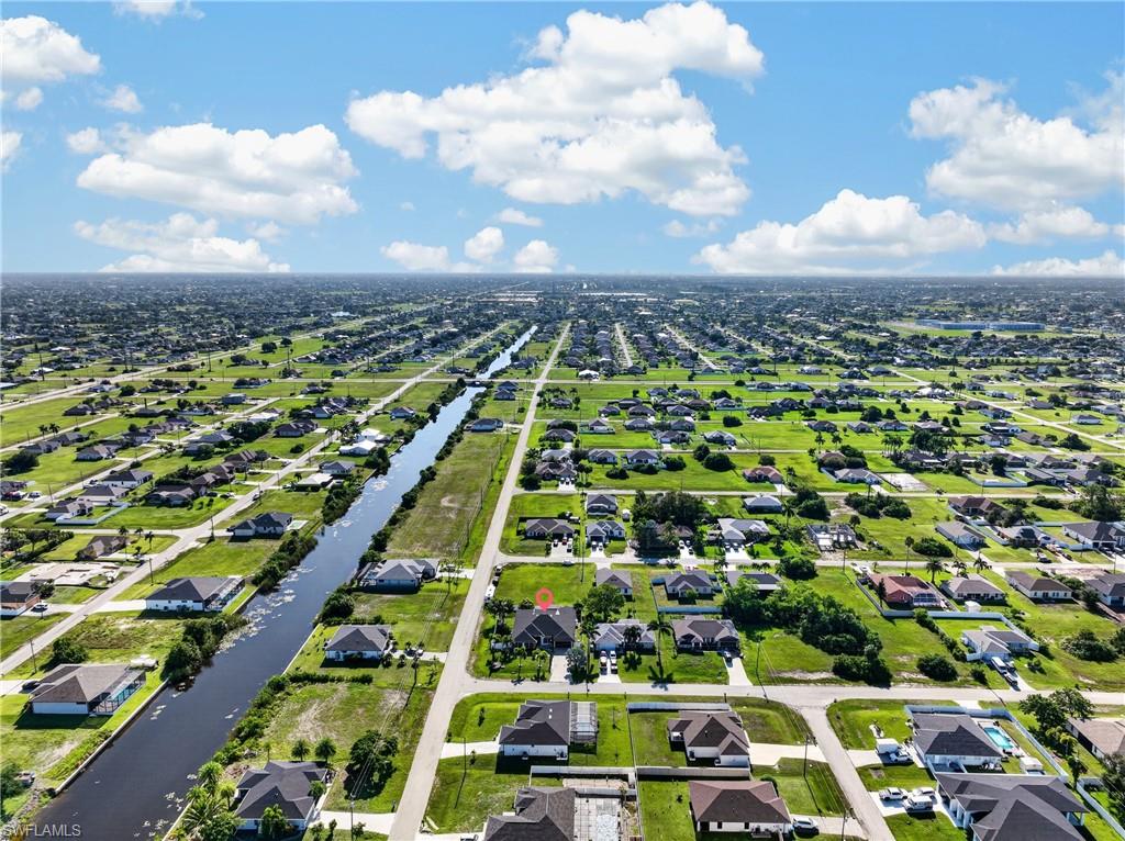 Additional contentThe image shows an aerial neighborhood view with multiple residential properties, waterways, and street layouts