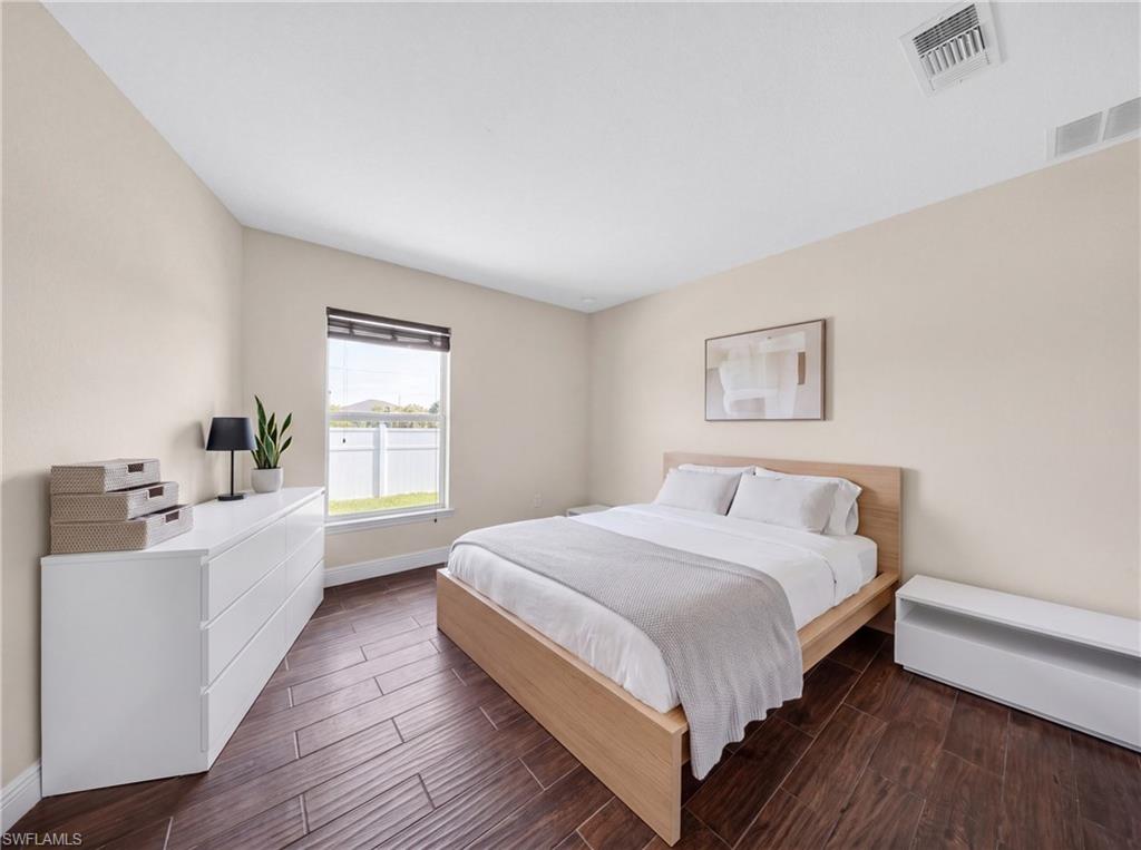 Wood-finish flooring throughout, with neutral wall tones and a window featuring horizontal blinds