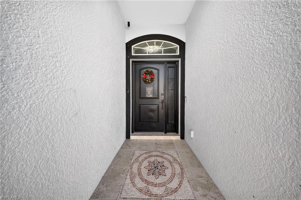 Arched transom window above a black entry door with sidelights