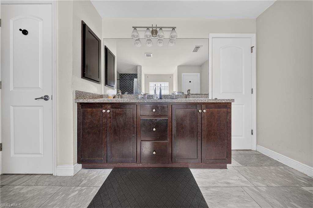 Dual vanity with dark wood-finish cabinetry, light-toned countertop, and undermount sinks