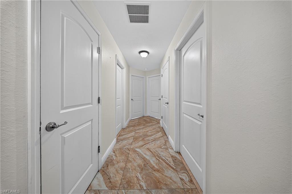 Hallway with light-toned walls and multiple arch-top panel doors