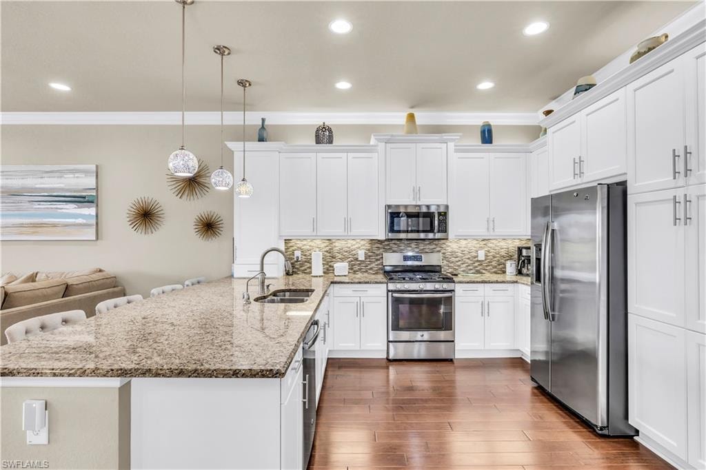 Open kitchen with granite counters, stainless steel appliances, high level cabinets with upper and under cabinet lighting, built-in pantry.