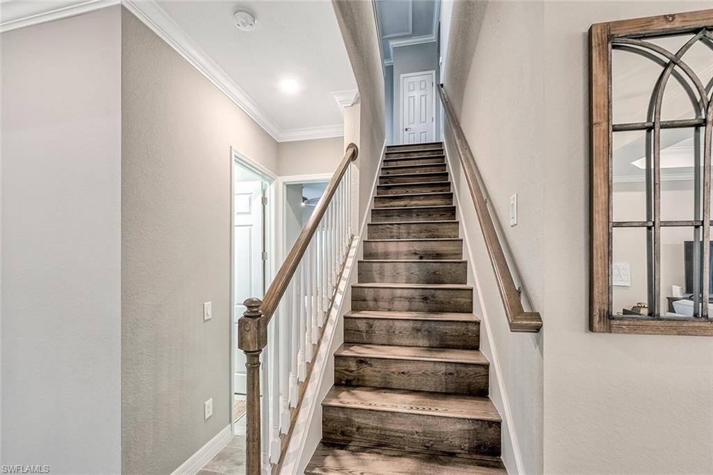 Staircase with ornamental molding and a textured wall