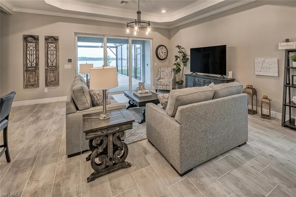 Living area featuring wood finish floors, a raised ceiling, and baseboards
