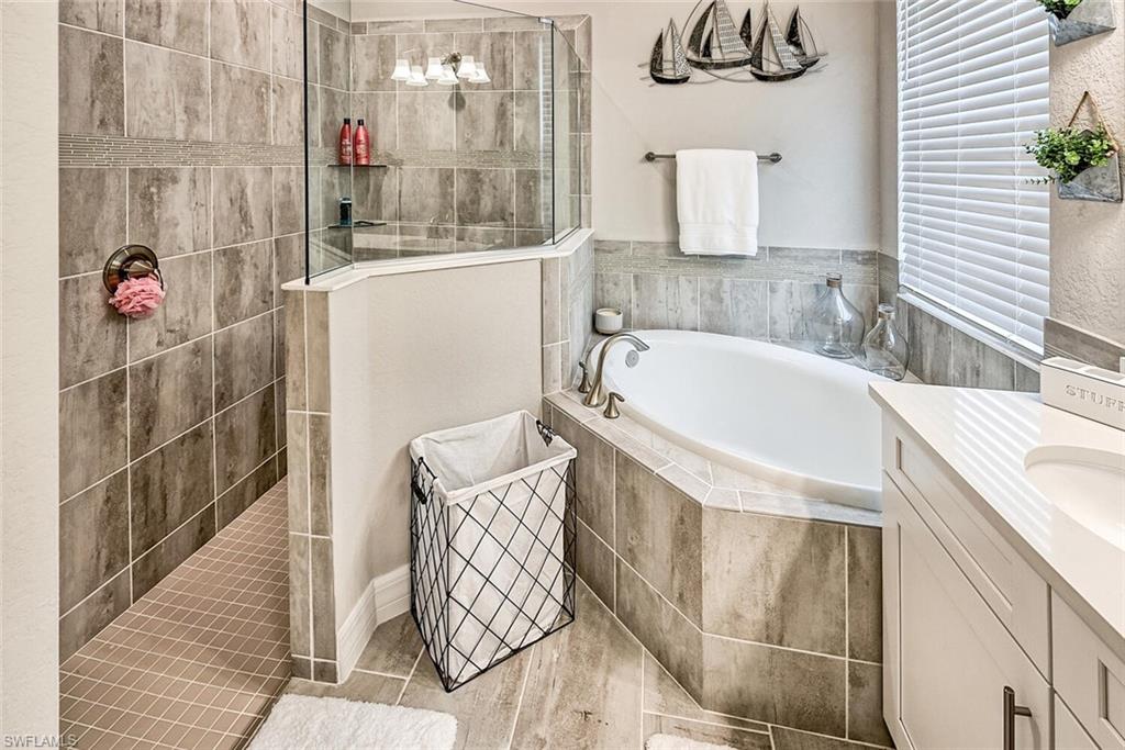 Full bathroom with vanity, a bath, and walk in shower