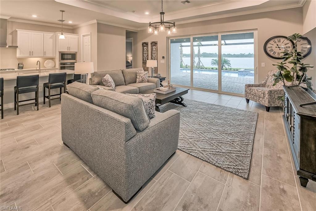Living room with recessed lighting, a notable chandelier, visible vents, wood tiled floor, and a tray ceiling