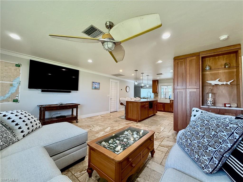 Recessed lighting, ceiling fan, built-in shelving, wood cabinetry, and tile flooring