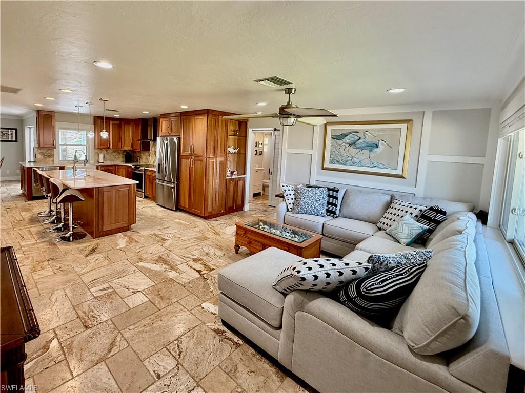 Spacious open-concept layout featuring a kitchen with wood cabinetry and stainless steel appliances