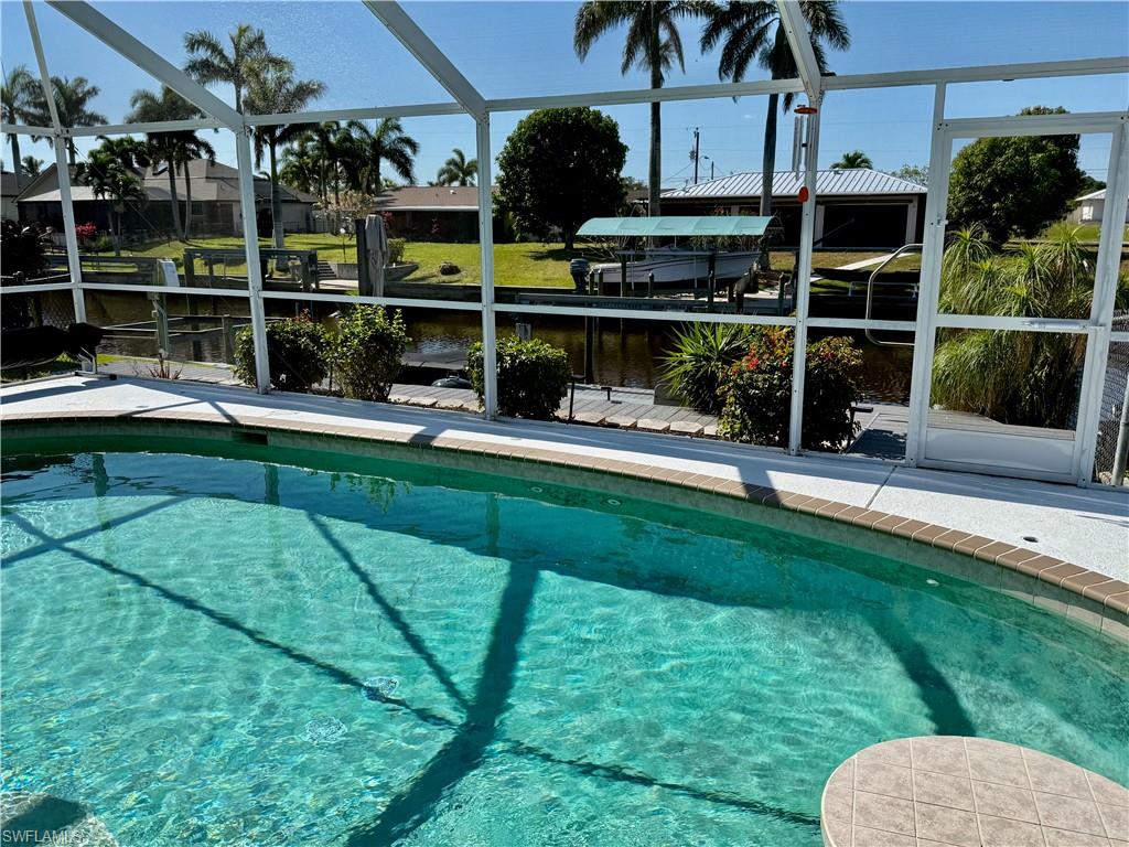 Screened swimming pool with a curved edge and a textured deck