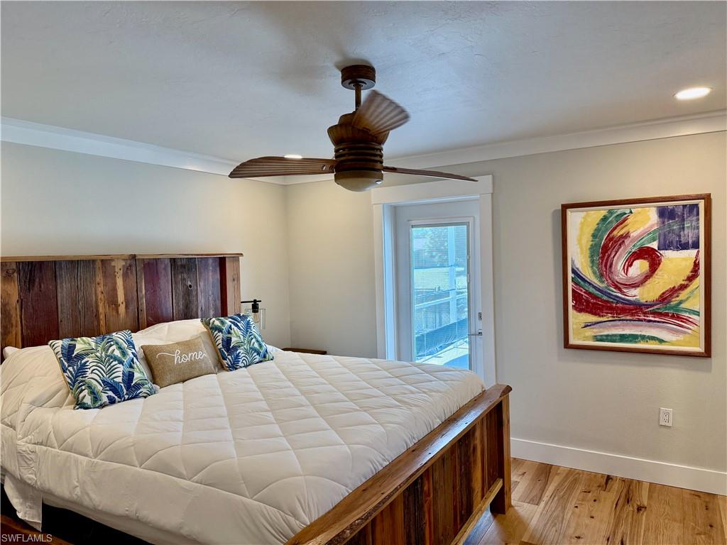 Hardwood flooring, crown molding, recessed lighting, ceiling fan, and French door