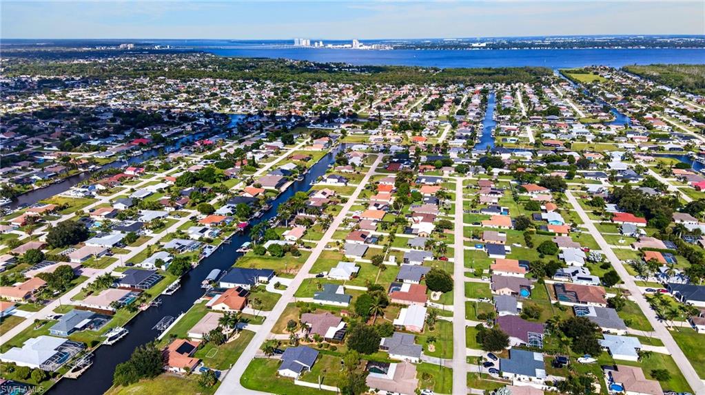 Waterfront community with canal access, established homes, and distant city skyline