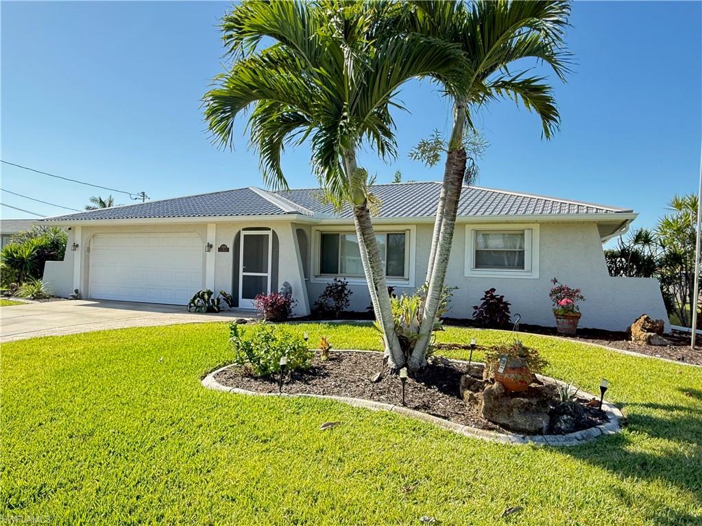 Light-colored exterior with a screened entry, attached garage, and a manicured lawn