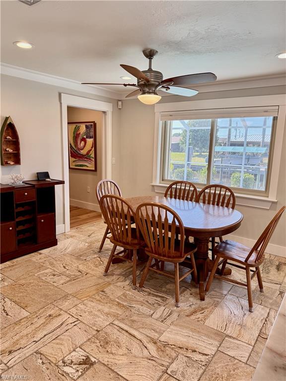 Recessed lighting, crown molding, ceiling fan with light, tiled flooring, and large window