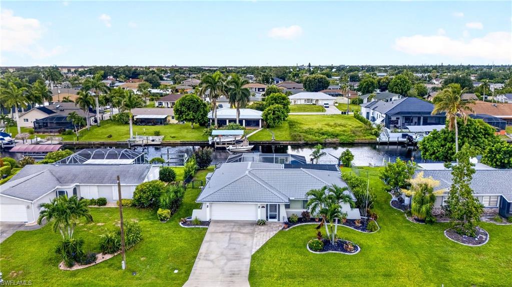 Single-story residence with an attached garage, featuring a tile roof and a paved driveway